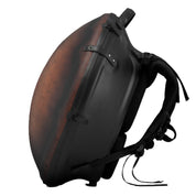 The Avaja Hardcase Vintage Style by Avaja is a sleek brown and black backpack with a rigid shell, padded shoulder harness, straps, and buckles—ideal for handpan transport. Photographed against a white background.