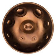 A top view of the Yatao // Shop MAG F# low pygmy 21 bronze handpan drum, featuring circular indentations and a central dome, inspired by Yatao Handpan craftsmanship, set against a white background.