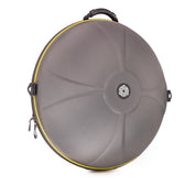 The TurtleCase Handpan Bag Evatek 2.0 medium HCT is a round, hard-shell gray case with a central logo, yellow zipper trim, black top handle, and sculpted front pattern, designed to protect handpans or similar round instruments.