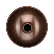 A top-down view of the YataoPan C# Pygmy 9 by Yatao // Shop, a metallic brown bowl-shaped instrument resembling a handpan or steel tongue drum, with a central opening and an engraving near the center.