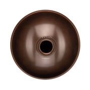 A top-down view of the YataoPan D Kurd 10, a round metallic brown handpan drum from Yatao // Shop, featuring stainless steel printed near its central opening.
