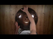 A person plays a YataoPan | D Kurd 10 432 Hz handpan drum, resting it on their lap. The text “YataoPan | D Kurd 10 432 Hz” appears on the left. Discover more at a Handpan Shop Germany or Buy Handpan online.