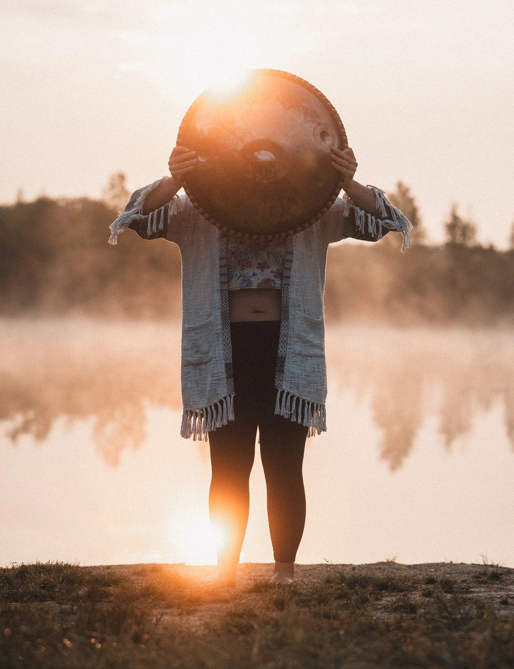Julie Follin mit Handpan bei Sonnenaufgang an einem See