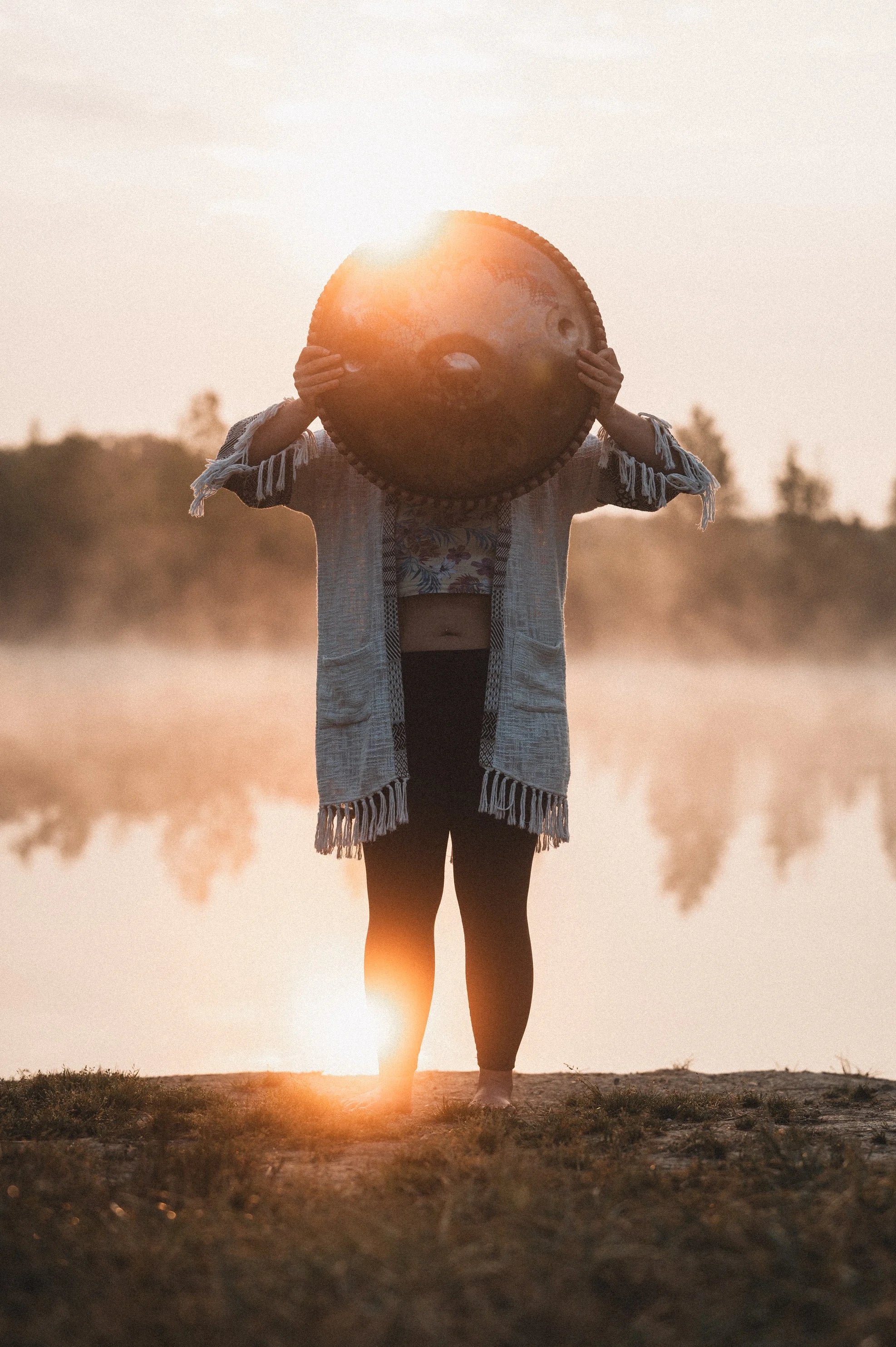 Julie Follin mit Handpan bei Sonnenaufgang an einem See
