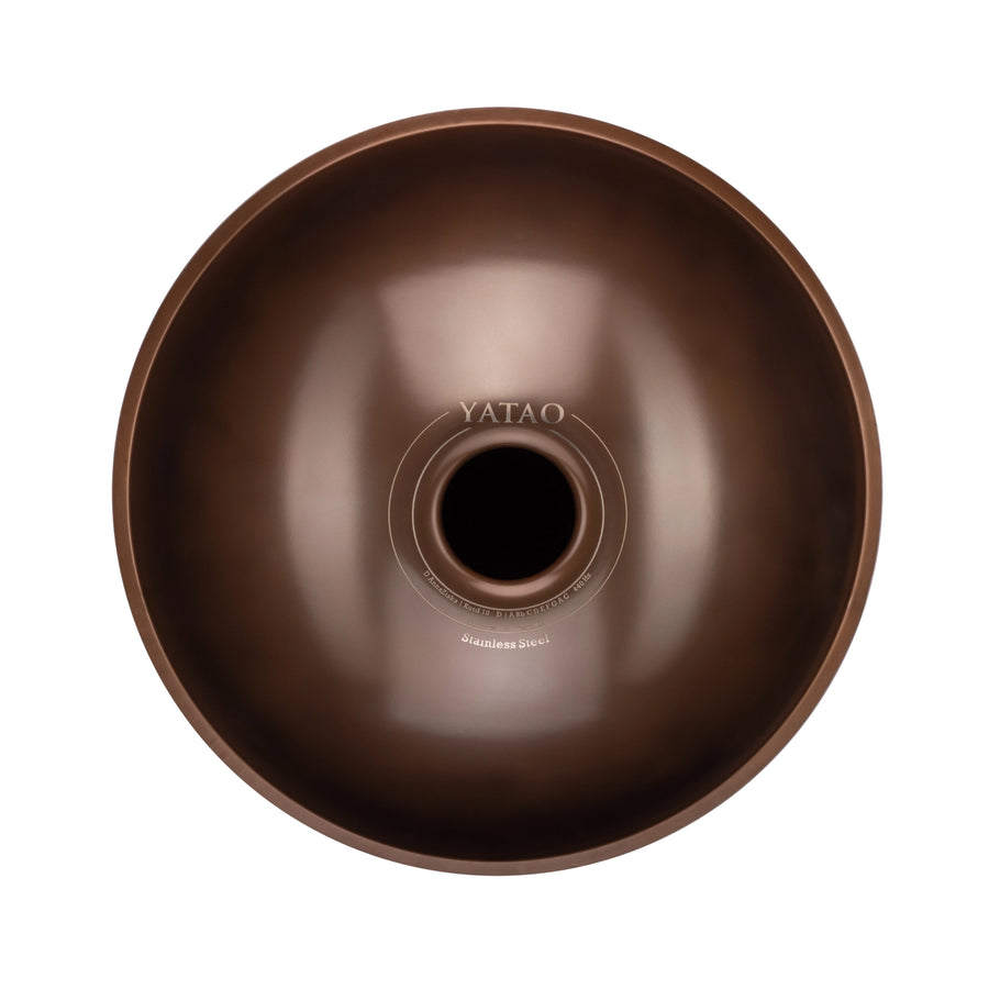 Yatao D Kurd 11 beginner handpan with visible Yatao branding, bottom view with central resonance port, bronze finish, isolated on a white background.