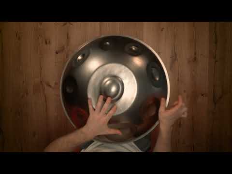 Thumbnail for Mudra F# Nordlys Stainless Steel handpan video, featuring a silver 15-note handpan played from a top-down perspective on a wooden background